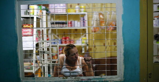 Una donna guarda dalla finestra del suo negozio situato all’interno di Torre de David. © REUTERS/Jorge Silva 