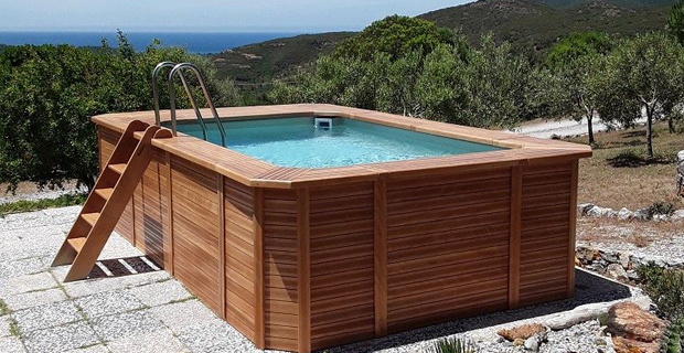 caption:Piscina fuori terra rettangolare rivestita di legno naturale della linea Solaire di Poolmaster.